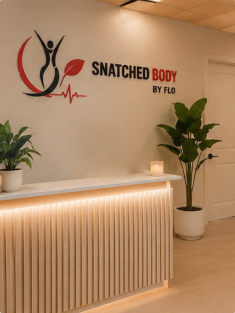 The reception desk at Snatched Body by Flo, with the studio sign on the wall